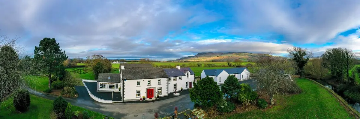 Aerial view of the farmhouse with mountains