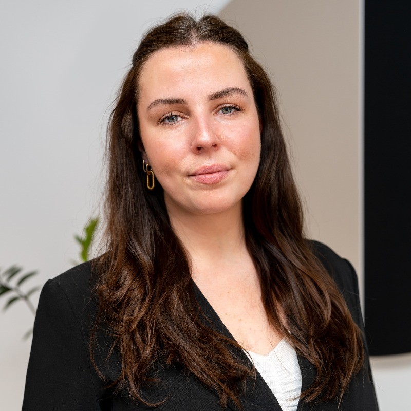 Louise in a black blazer against a light background.